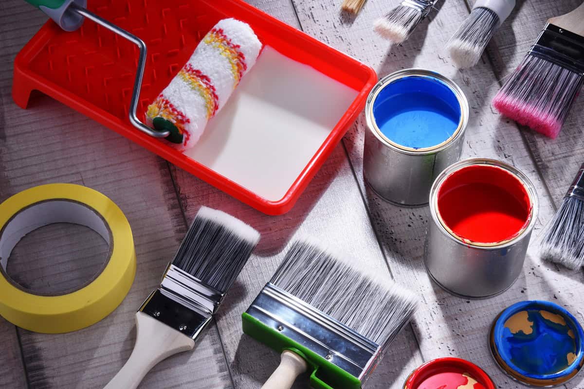 Paintbrushes of different size and paint can